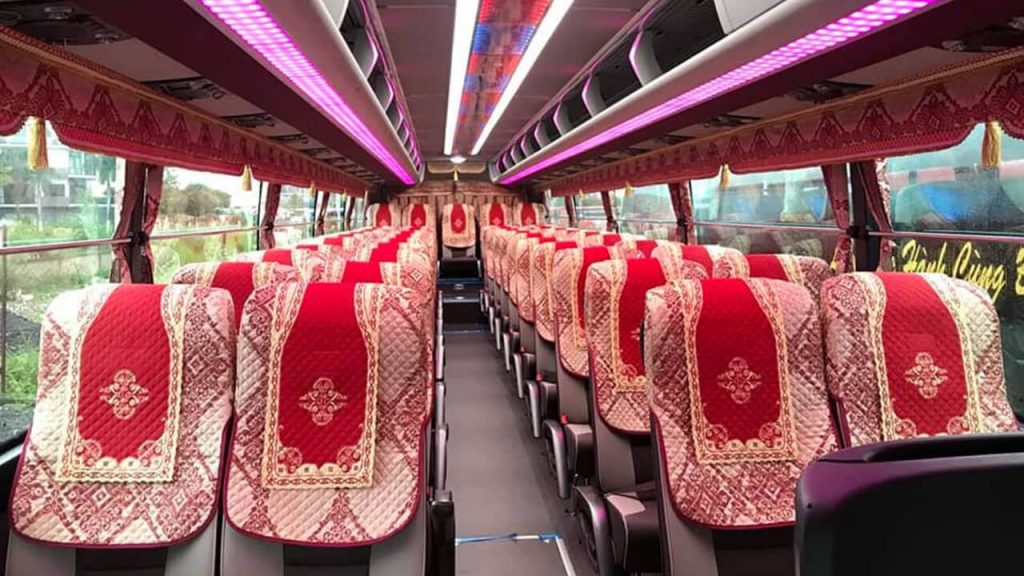 Plush reclining seats, high-efficiency dual air conditioning, and wide center aisle inside 45-seater coach for Da Lat tour
